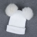 White knit beanie with two large faux fur pom-poms