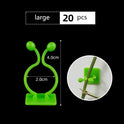Green leaf-shaped self-adhesive plant fixture clip supporting climbing plants on wall